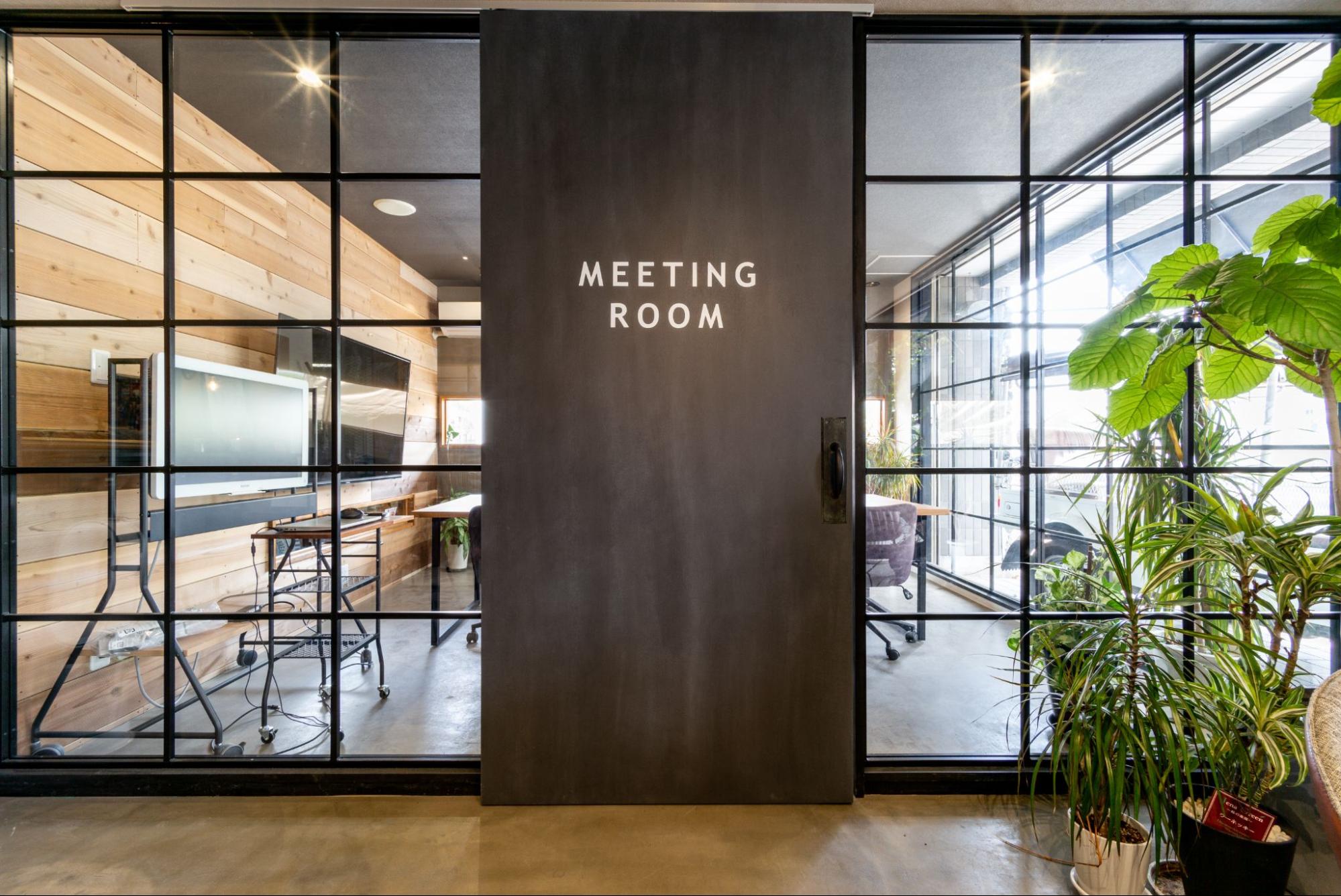 「MEETING ROOM」と書かれた黒い引き戸が中央にある、ACE FORMのオフィスミーティングルーム。