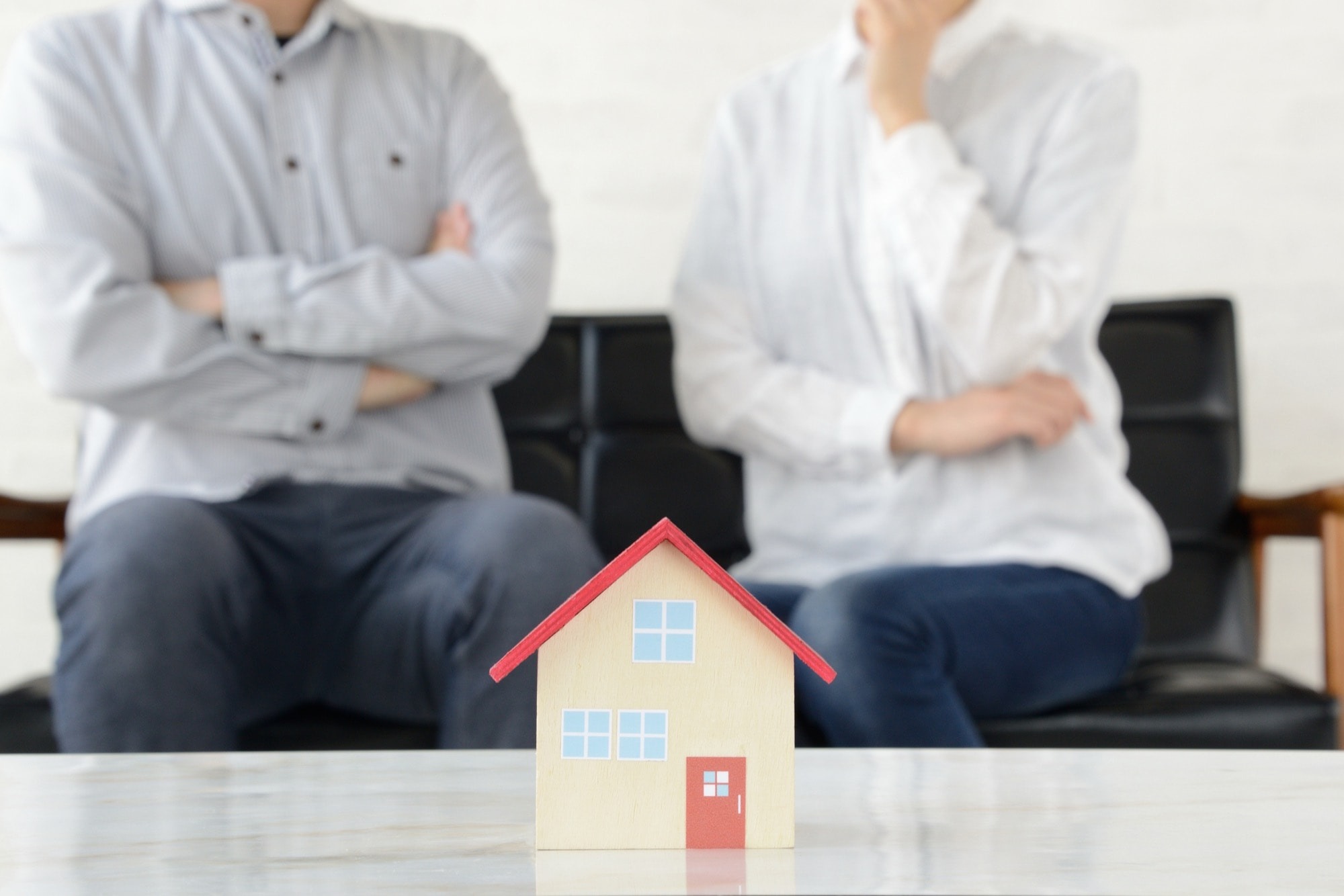 家の模型を見ながら悩む夫婦