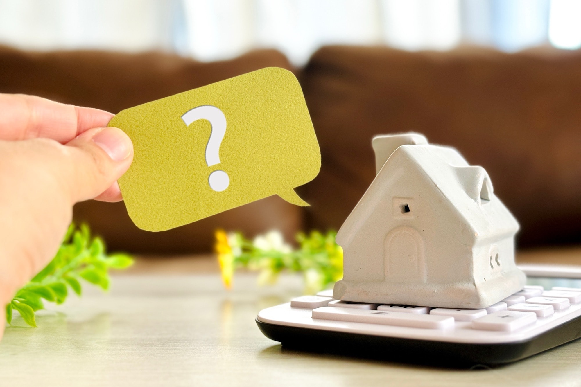 住宅とはてなマークを持つ手