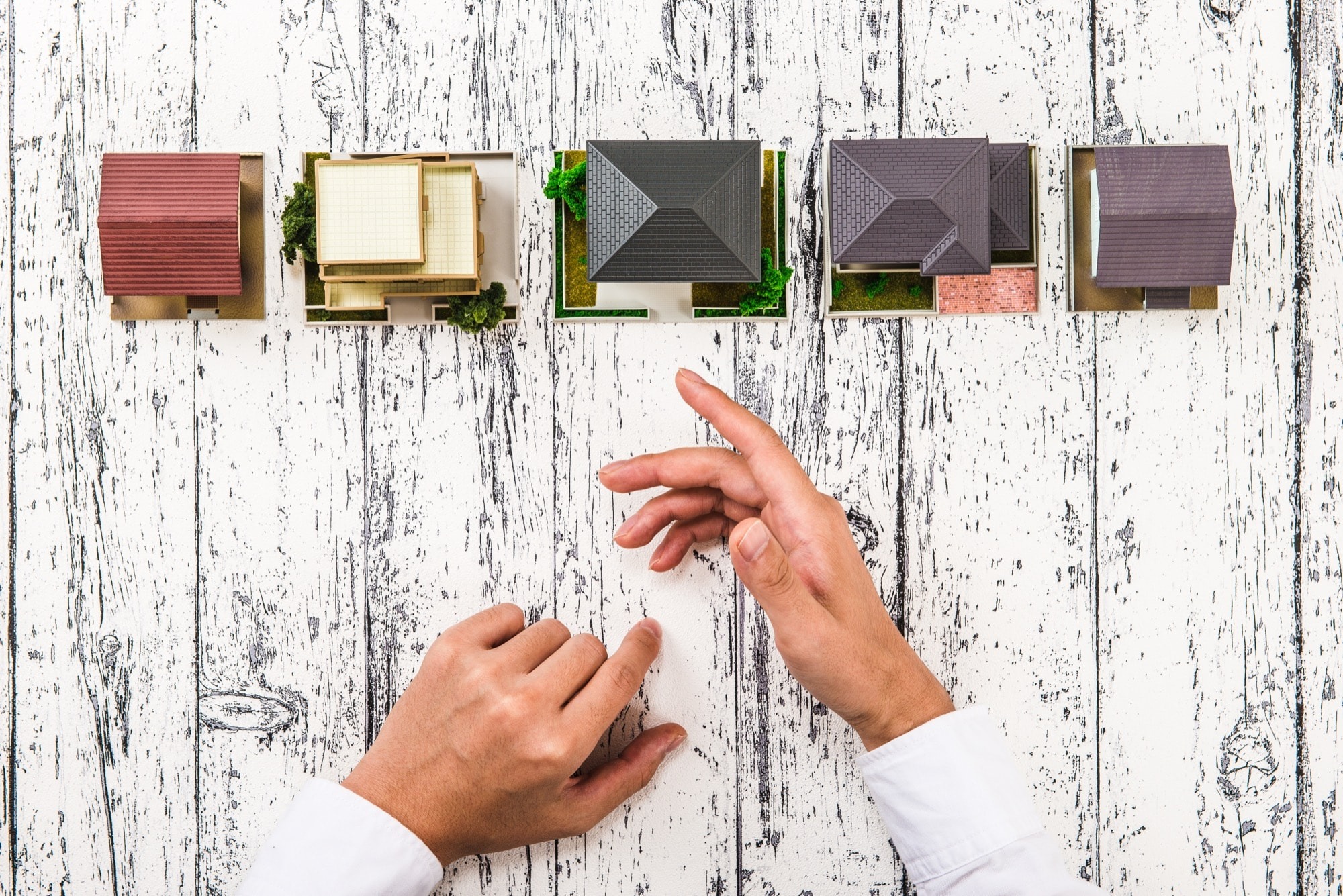 家の模型を置いて、手のジェスチャーを交え解説する人