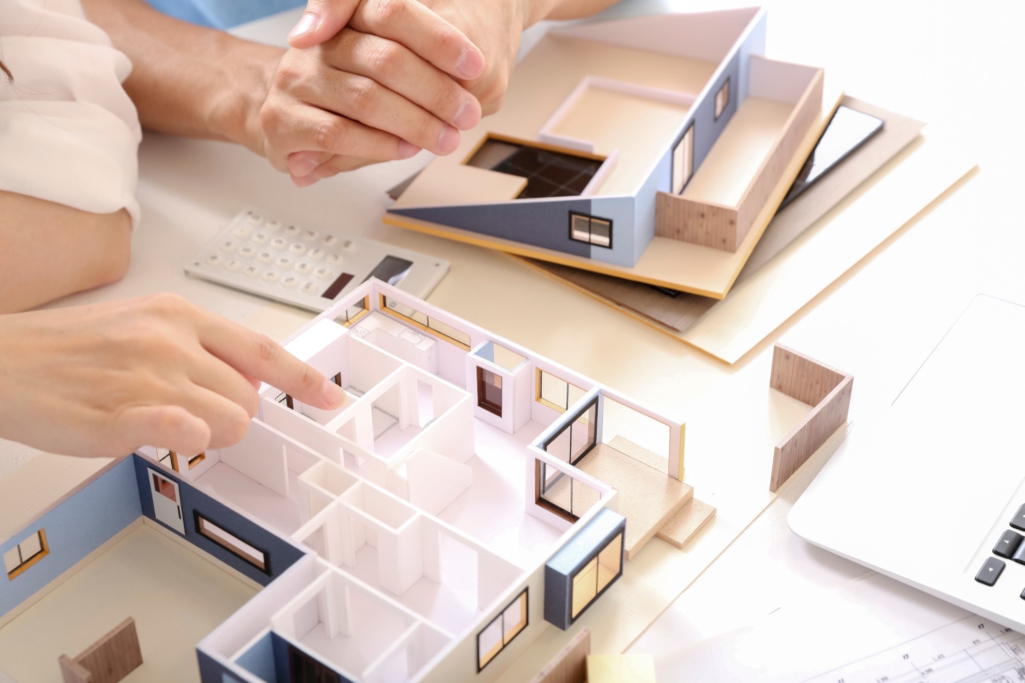 住宅模型を見ながら話し合いをする2人